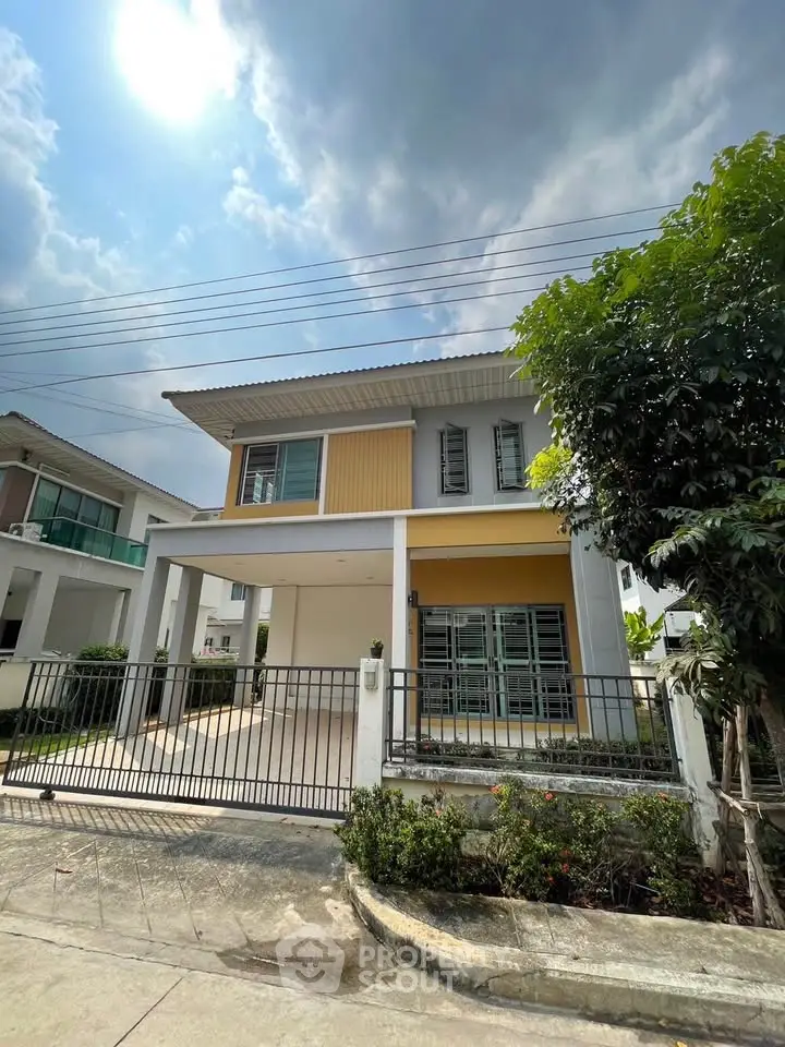 Modern two-story house with a spacious driveway and lush greenery, perfect for family living.