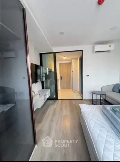 Modern bedroom with sleek design and glass partition in a stylish apartment.