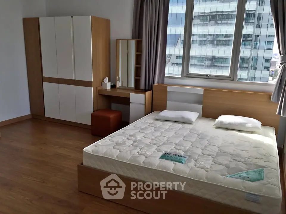 Spacious bedroom with modern furniture and large window view