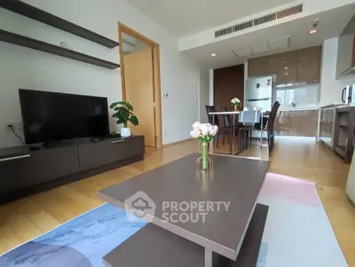 Modern living room with sleek furniture and open kitchen layout in a stylish apartment.