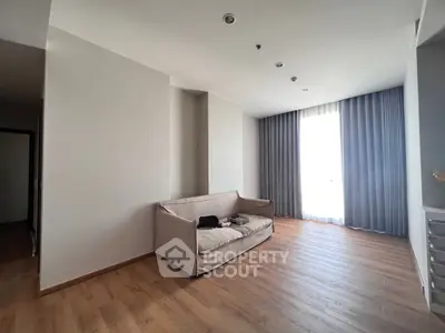 Spacious living room with elegant curtains and wooden flooring, perfect for modern living.