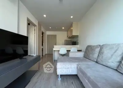 Modern living room with sleek furniture and open kitchen layout in a stylish apartment.