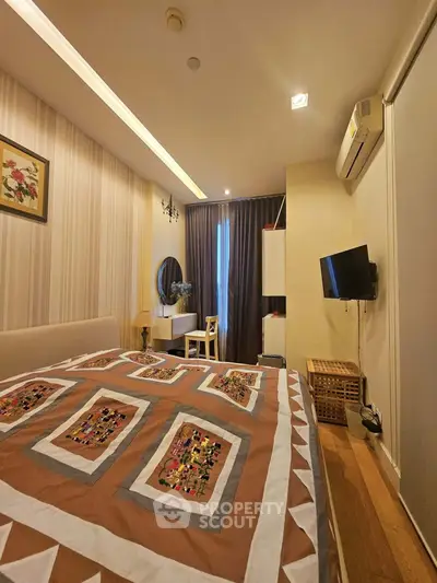 Cozy bedroom with stylish decor and modern amenities, featuring a comfortable bed and wall-mounted TV.