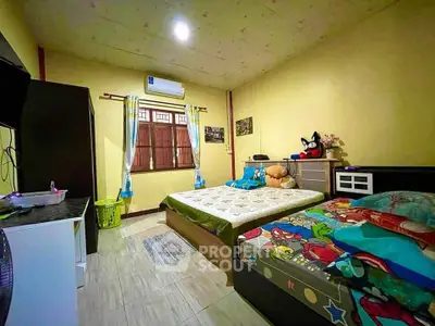 Cozy bedroom with twin beds and colorful decor in a well-lit space.