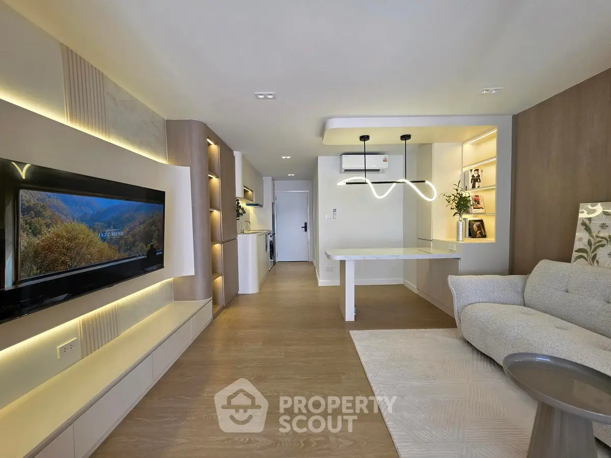 Modern living room with sleek design and open layout, featuring stylish lighting and cozy seating.