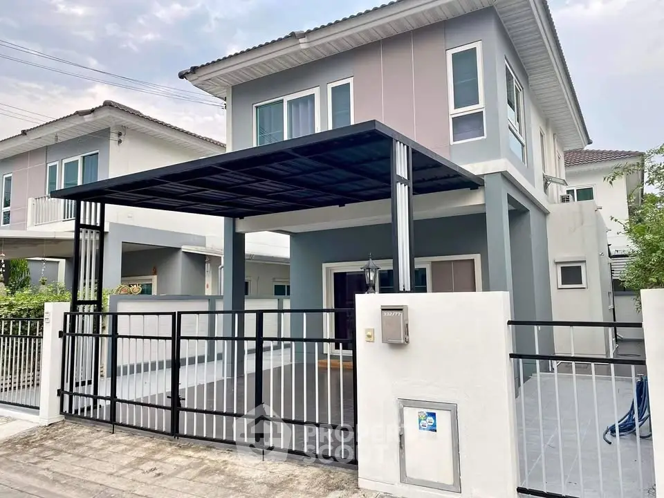 Modern two-story house with gated driveway and sleek exterior design.