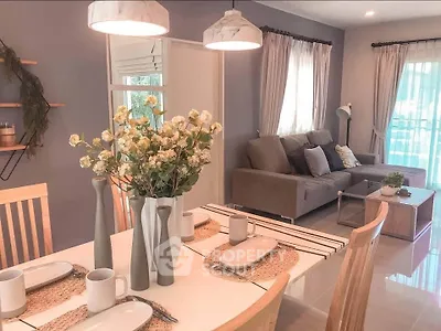 Charming open-plan living and dining area with cozy decor and natural light.