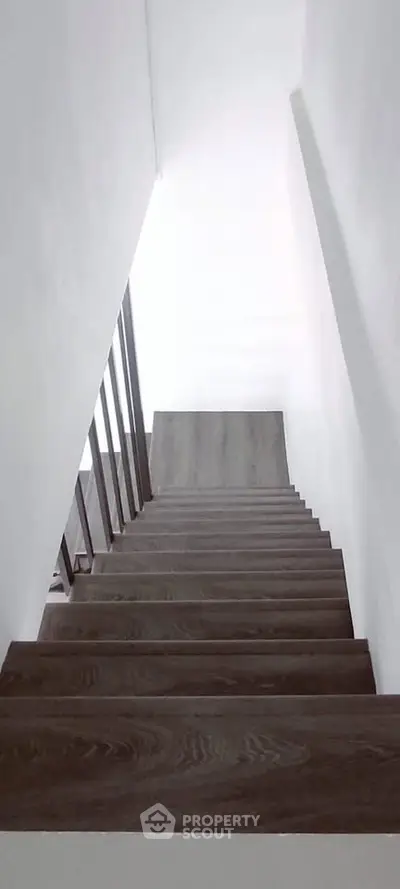 Modern wooden staircase with sleek design in a contemporary home interior.