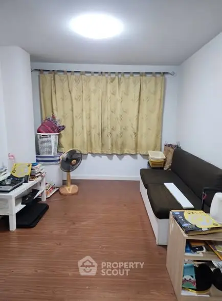 Cozy living room with wooden flooring and a comfortable sofa, perfect for relaxation.