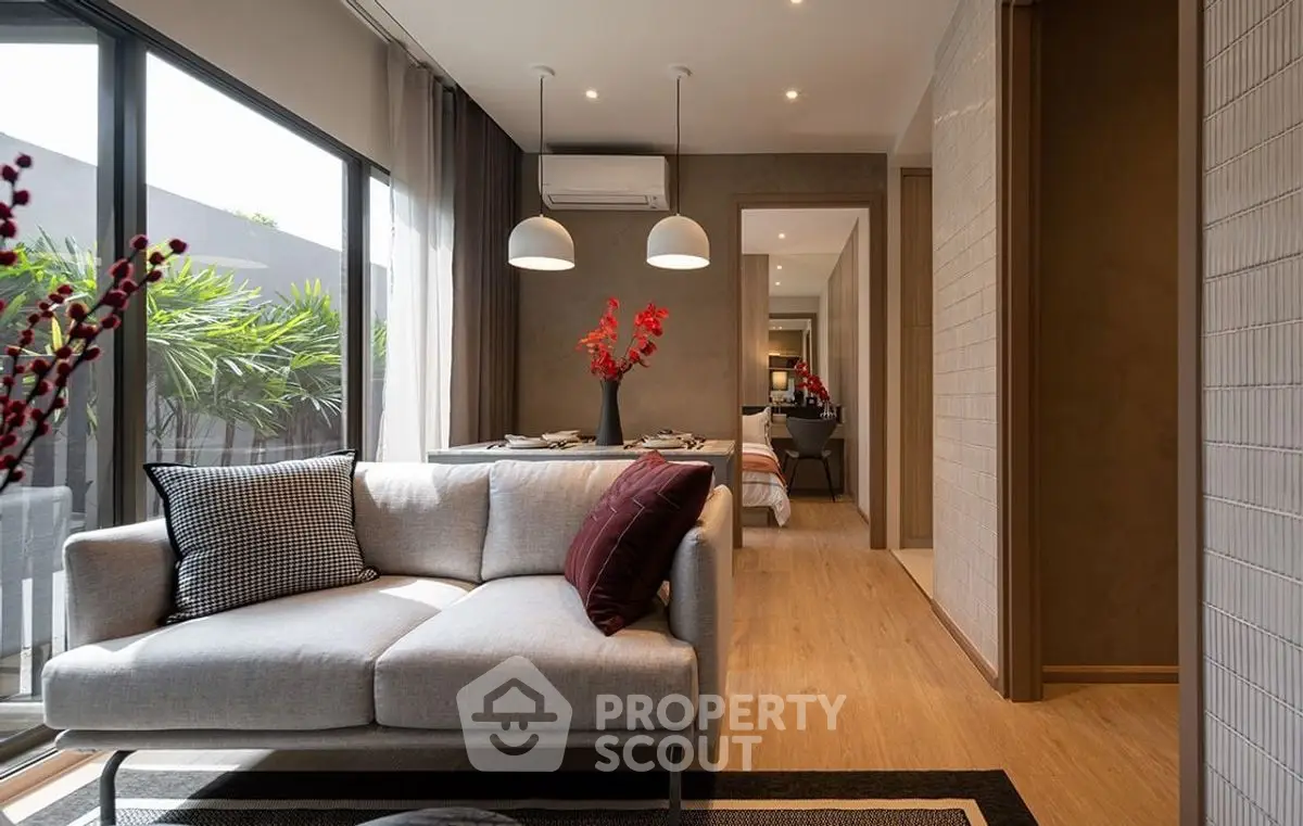 Modern living room with stylish decor and natural light, featuring a cozy sofa and elegant dining area.