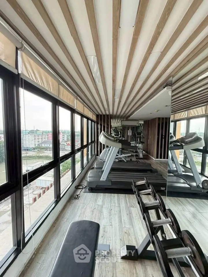 Modern gym with panoramic windows and state-of-the-art equipment in a luxury residential building.