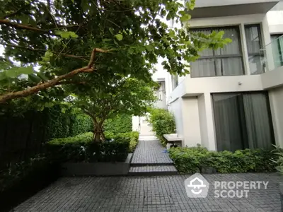 Modern residential building with lush garden and paved walkway