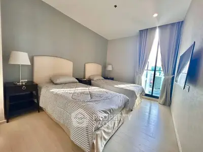 Bright bedroom with twin beds and balcony access in modern apartment