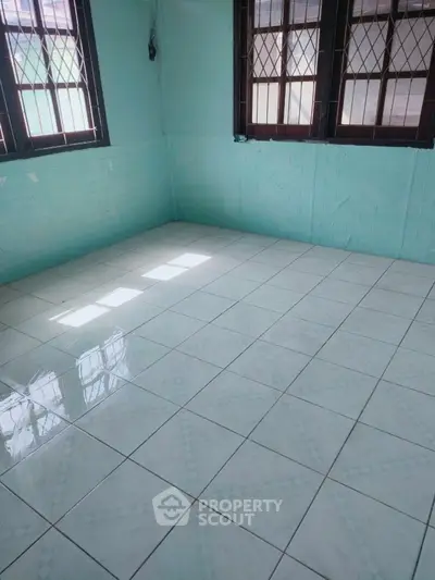 Bright empty room with tiled floor and barred windows, perfect for customization.