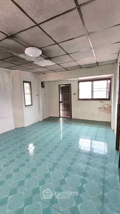 Spacious room with tiled floor and large windows, ideal for customization.