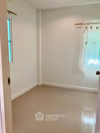 Spacious empty room with natural light and neutral tones, perfect for customization.