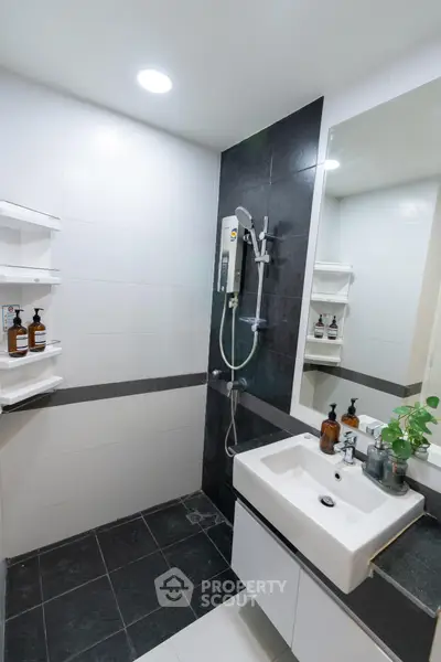 Modern bathroom with sleek design, featuring a stylish sink and shower area, perfect for contemporary living.