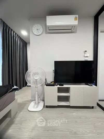Modern bedroom with air conditioning, TV, and sleek furnishings in a stylish apartment.