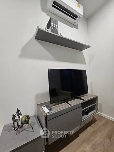 Modern living room with sleek TV stand, air conditioning, and stylish decor.