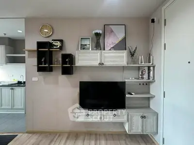 Modern living room with stylish wall-mounted shelves and TV, adjacent to a sleek kitchen area.