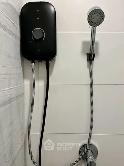 Modern bathroom shower with sleek black water heater and chrome showerhead.
