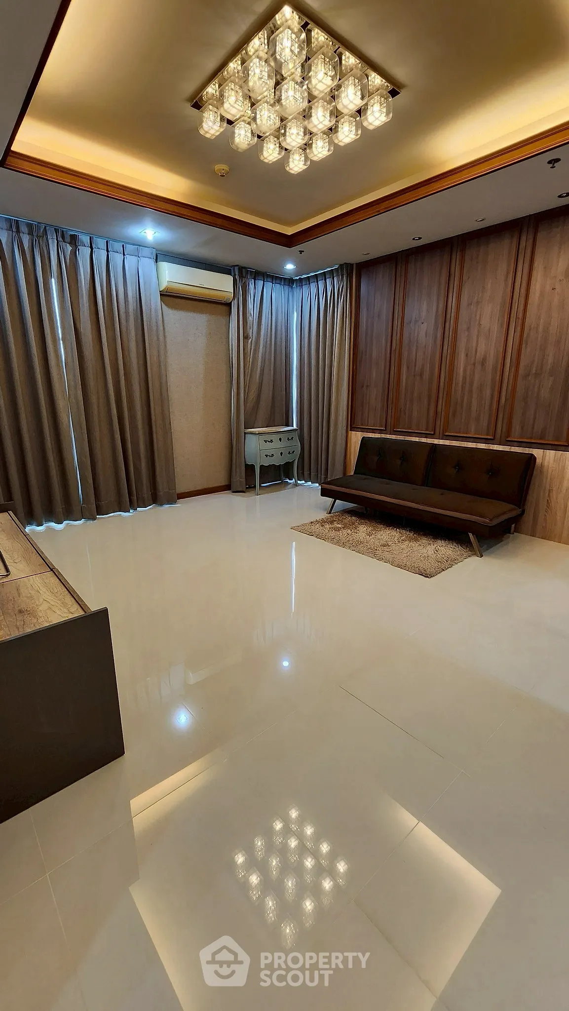 Spacious modern living room with elegant lighting and sleek furnishings.