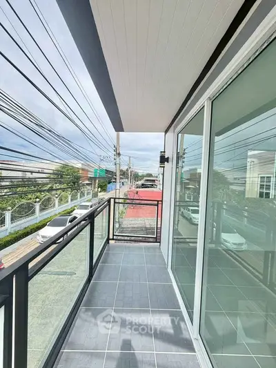 Modern balcony with glass railing offering street view in urban setting