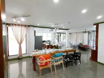 Spacious open-plan dining and living area with modern decor and ample natural light.