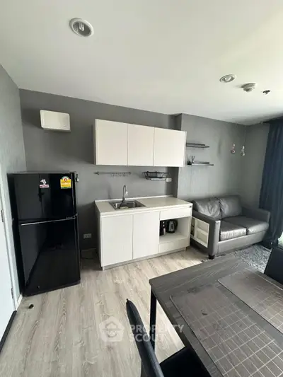 Modern apartment kitchen with sleek cabinetry and cozy living area, perfect for urban living.