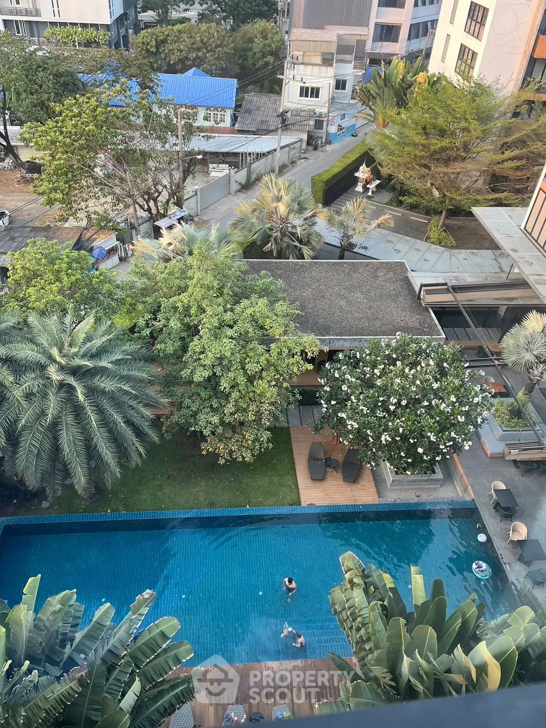Stunning aerial view of a luxurious pool surrounded by lush greenery in a modern residential complex.