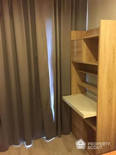 Cozy study nook with wooden shelves and desk, perfect for home office setup.