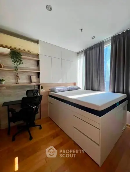 Modern bedroom with built-in storage and workspace, featuring natural light and sleek design.
