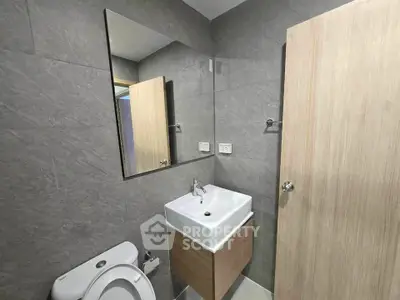 Modern bathroom with sleek sink and toilet in minimalist design.
