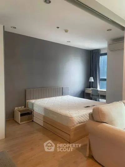 Modern bedroom with stylish decor and natural light, featuring a comfortable bed and work desk.