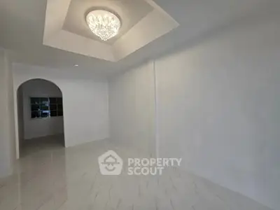 Spacious empty room with elegant chandelier and marble flooring