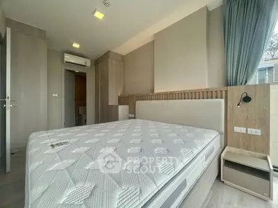 Modern bedroom with large bed and natural light, featuring sleek design and neutral tones.