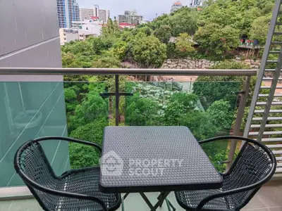 Charming balcony with lush green view in urban setting, perfect for relaxation and enjoying nature.
