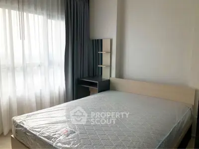 Modern bedroom with natural light and stylish furnishings in a contemporary apartment.