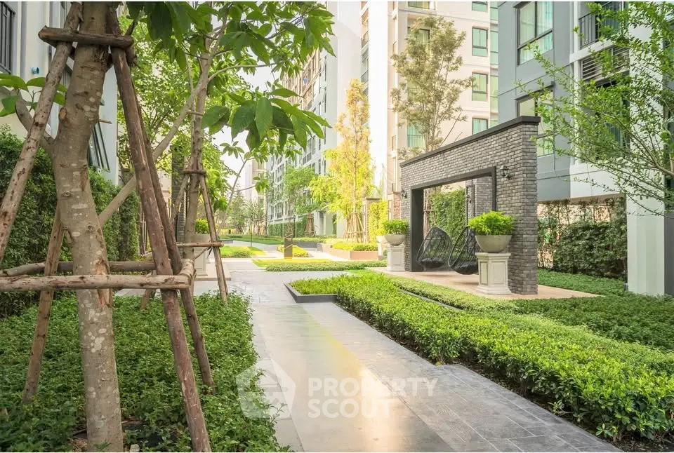 Luxurious garden view of modern apartment complex with lush greenery and elegant landscaping.