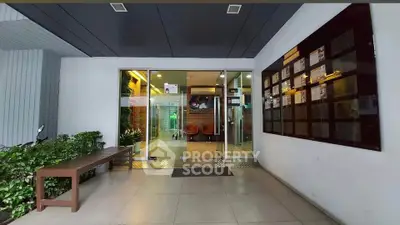 Modern building entrance with glass doors and seating area