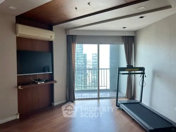 Spacious living room with treadmill and balcony view in modern apartment