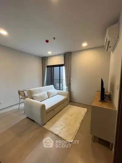 Modern living room with cozy sofa, TV, and dining area in a stylish apartment.