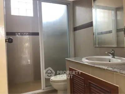 Modern bathroom with glass shower and sleek vanity in a contemporary home.