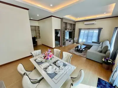 Spacious modern living room with elegant dining area and cozy seating, perfect for family gatherings.