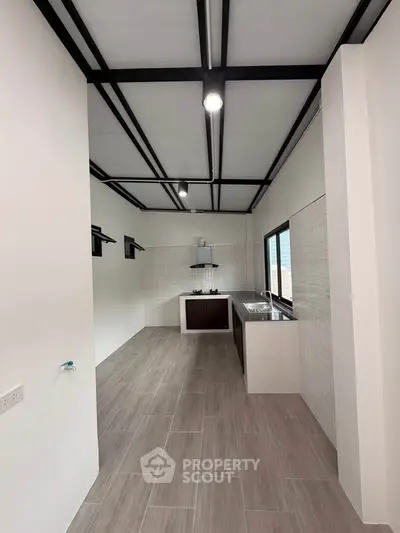 Modern kitchen with sleek design and open layout, featuring large windows and contemporary fixtures.