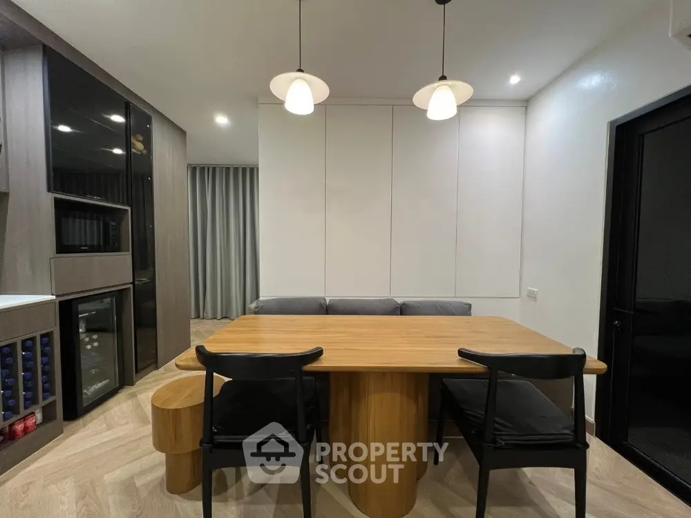 Modern dining area with wooden table and stylish lighting in contemporary home