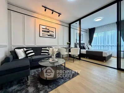 Modern open-plan living room with elegant decor and cozy bedroom view