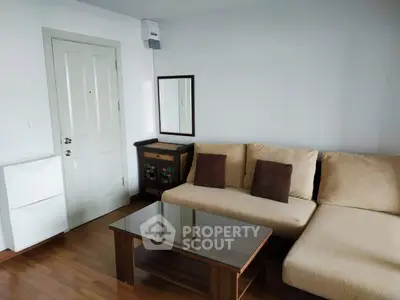Cozy living room with beige sofa, wooden coffee table, and decorative cabinet in modern apartment.