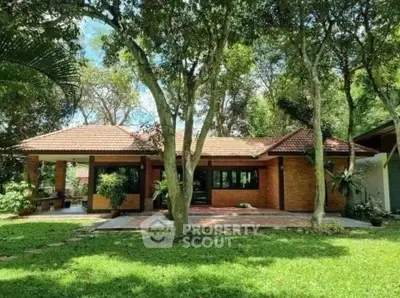 Charming single-story home with lush garden and brick facade, perfect for nature lovers.