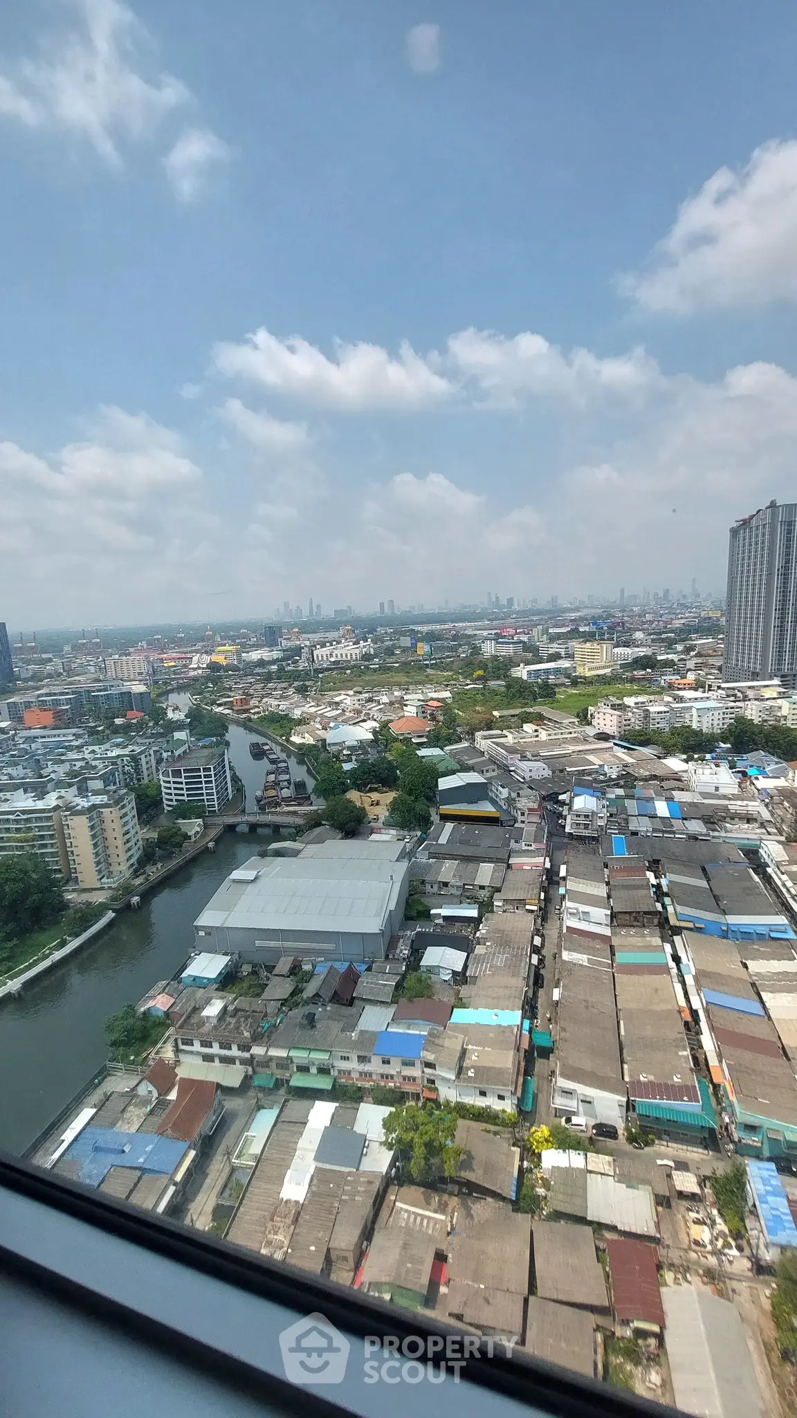 Stunning cityscape view from high-rise building window showcasing urban landscape and river.